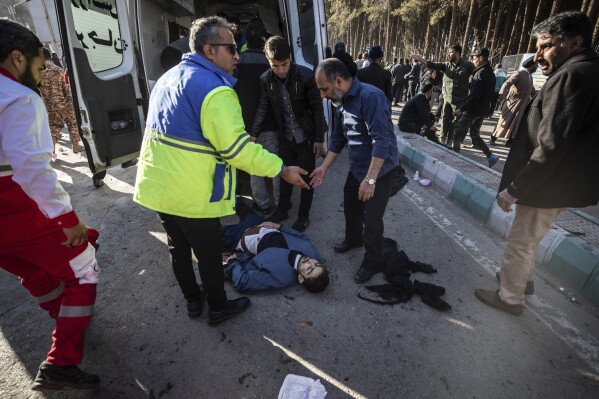 An injured man gets aid after an explosion in Kerman, Iran, Wednesday, Jan. 3, 2024. Iran says the deadly twin bomb blasts occurred at an event honoring a prominent Iranian general slain in a U.S. airstrike in 2020. (Mahdi Karbakhsh Ravari/Mehr News Agnecy via AP)